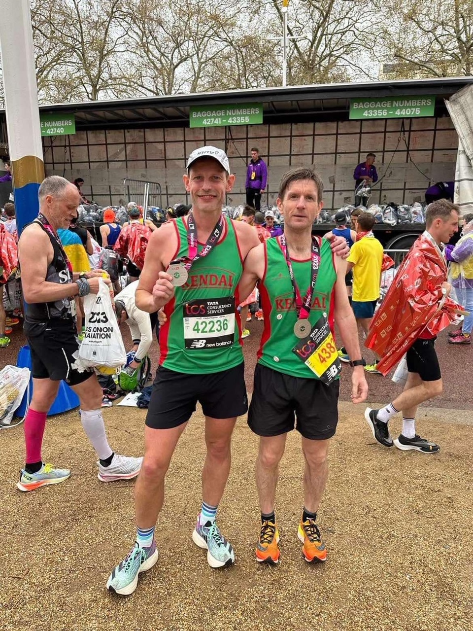 Two Kendal AAC athletes after a race wearing medals